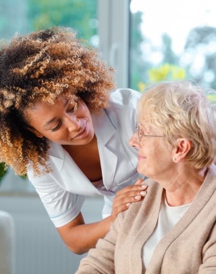 A caregiver assisting a senior woman with a smile. Providing compassionate senior care.